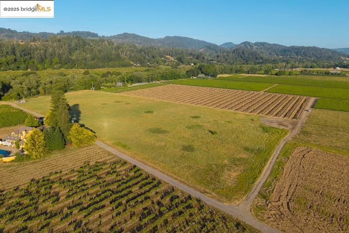 Aerial overview of property's location with farmland, rural landscape, and a mountainous background