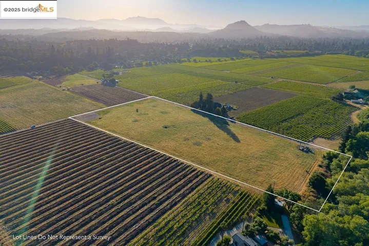 Aerial view of sparsely populated area featuring property boundaries highlighted, mountains, and extensive farmland