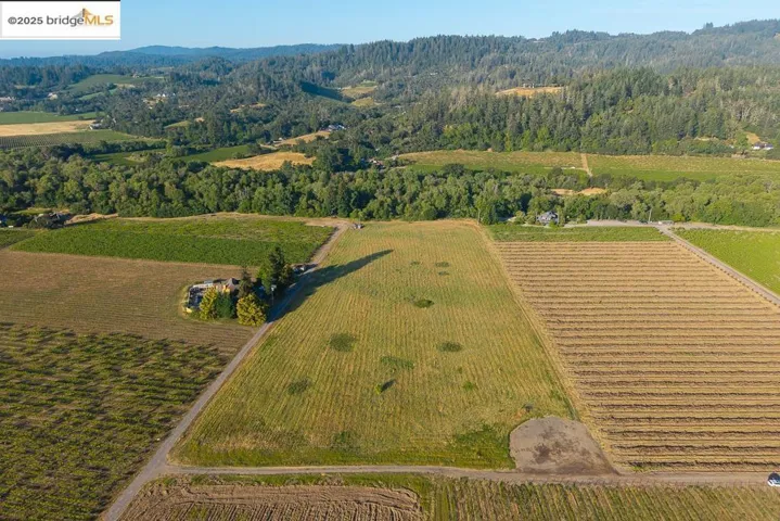 Aerial view of property and surrounding area with a forest and rural landscape