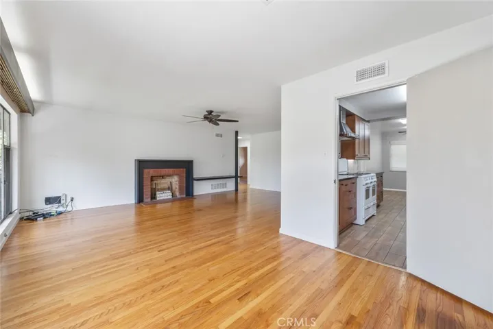 Looking out from the dining room at 10357 Lesterford Avenue onto the living room fireplace, the yard and the pool.
