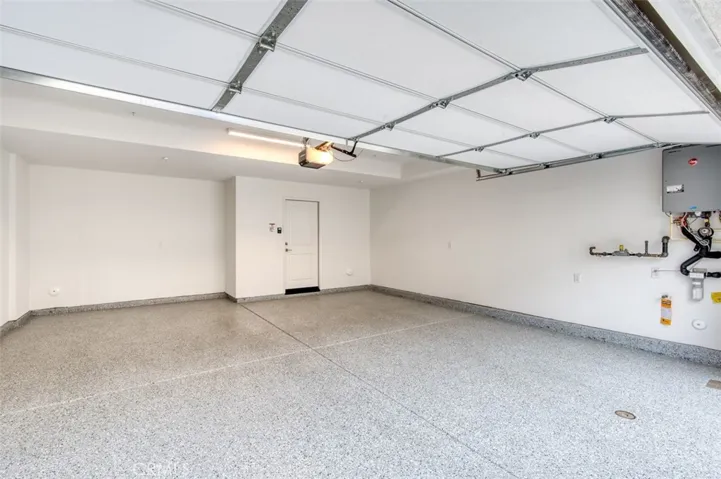 Direct access 2-car epoxy floor garage with Rheem tankless water heater.