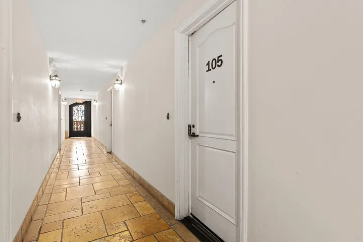 Interior hallway entry is equipped with stone flooring.