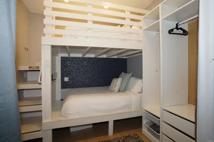 10' ceilings allows for oversize, custom, queen bunk beds.  Desk and wardrobe in room .