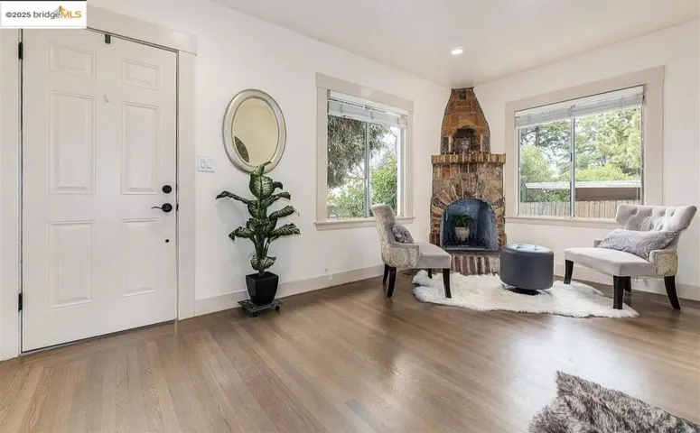 Living area with wood finished floors, healthy amount of natural light, recessed lighting, and a fireplace