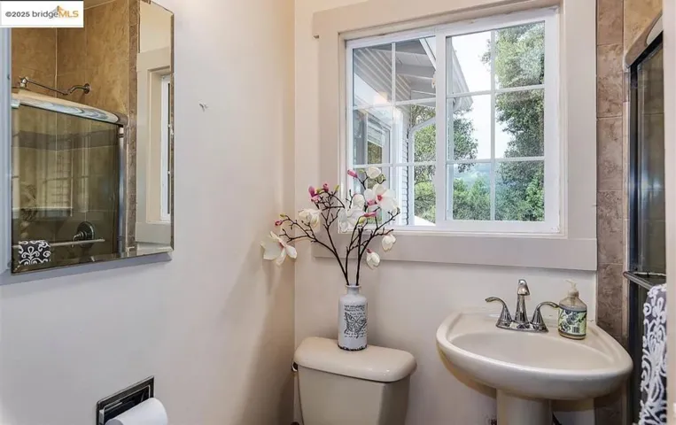 Full bathroom with a tile shower and toilet