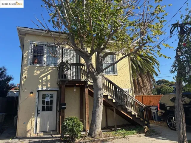 View of front facade with stairs and stucco siding