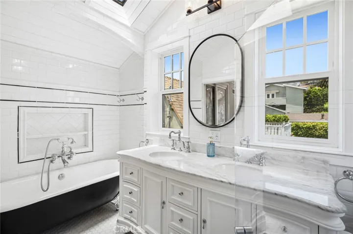 With an ensuite bath featuring vintage-inspired tilework, a soaking tub, and marble countertops.