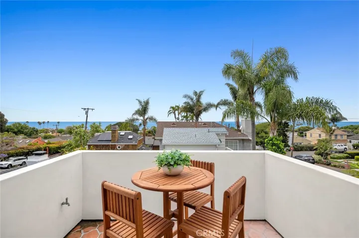 Upstairs, the spacious primary suite offers a private deck with ocean, hillside, and evening-light views.