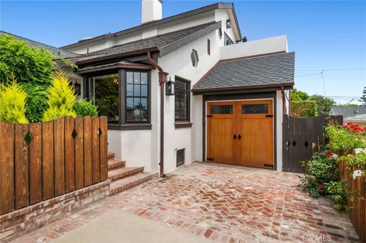 A one-car garage is complemented by a long driveway with generous parking or optional outdoor recreation space.