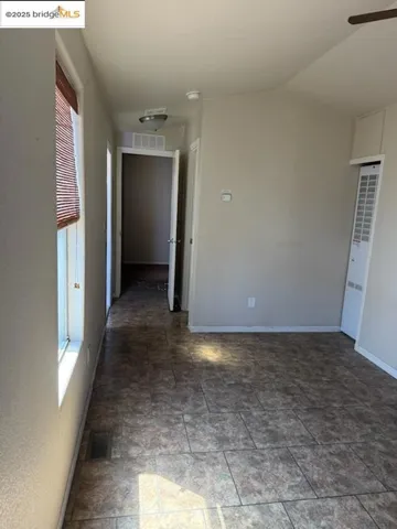 Unfurnished room with vaulted ceiling and a heating unit