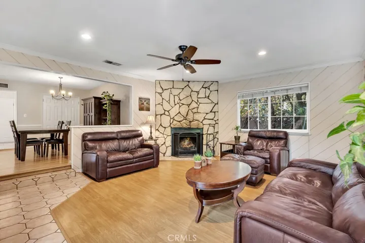Family Room
Smooth ceilings
Crown molding
Ceiling fan
LED recessed lights
Floor-to-ceiling rustic stone fireplace 
Sliding glass door showcasing the backyard view
Gleaming laminated wood and tile floors