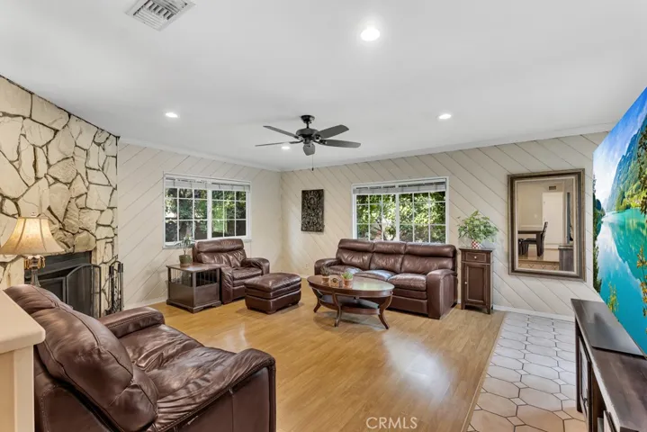 Family Room
Smooth ceilings
Crown molding
Ceiling fan
LED recessed lights
Floor-to-ceiling rustic stone fireplace 
Sliding glass door showcasing the backyard view
Gleaming laminated wood and tile floors