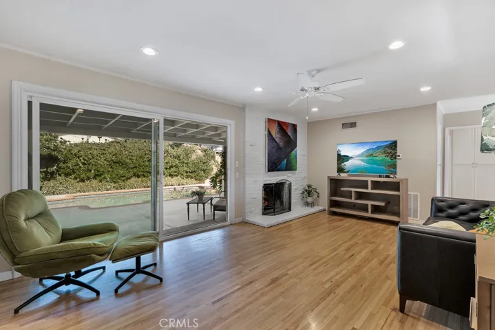 Living Room

Front door with glass inserts
Energy efficient dual pane windows
Smooth ceilings 
Crown molding
Ceiling fan
LED recessed lights
Floor-to-ceiling fireplace in white-painted brick
Oversized sliding glass door leading to the backyard
Rich hardwood floors