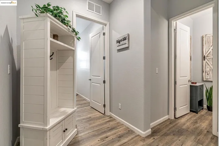 Mudroom with a textured wall and light wood-type flooring