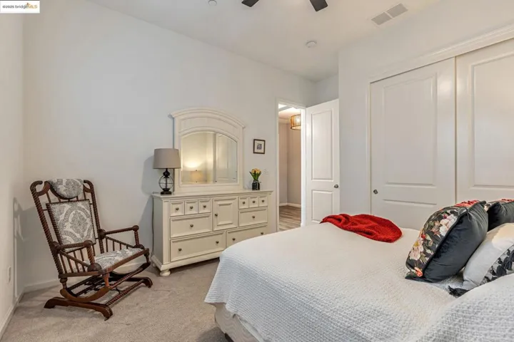 Bedroom with light colored carpet, a ceiling fan, and a closet