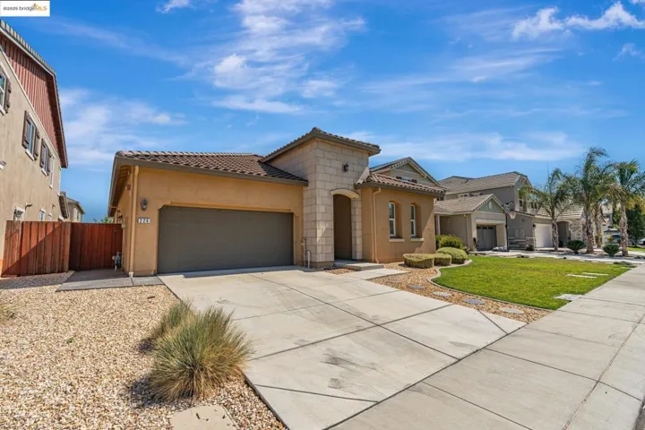 Mediterranean / spanish-style home featuring stucco siding, driveway, an attached garage, and a tile roof