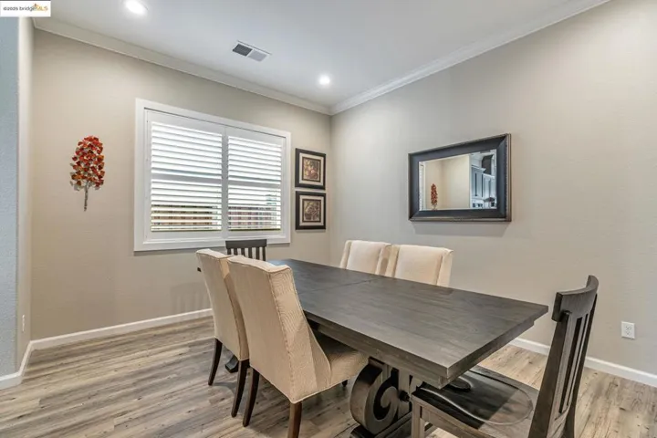 Dining space featuring ornamental molding, light wood finished floors, and recessed lighting