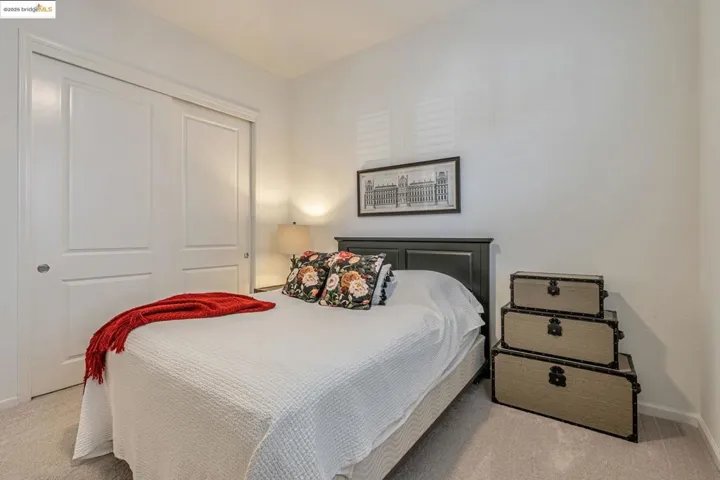 Bedroom with light carpet and a closet