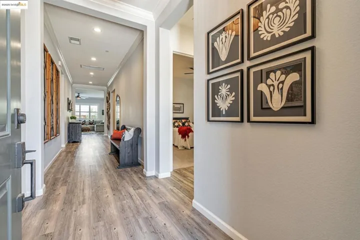 Hallway with ornamental molding, light wood-style flooring, and recessed lighting