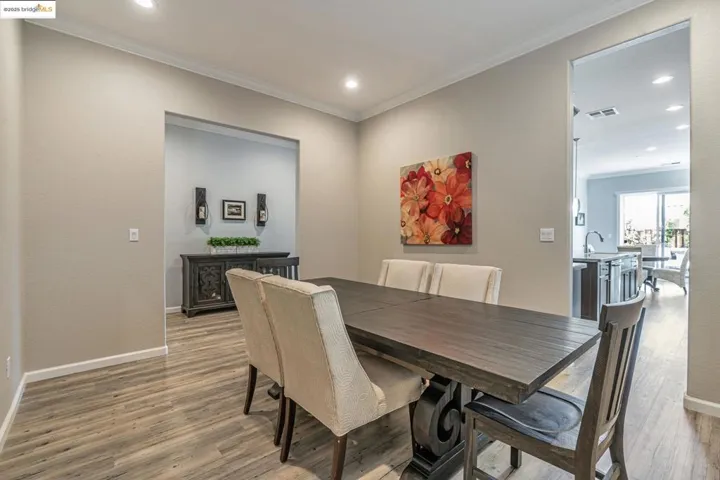 Dining room with ornamental molding, recessed lighting, and light wood finished floors