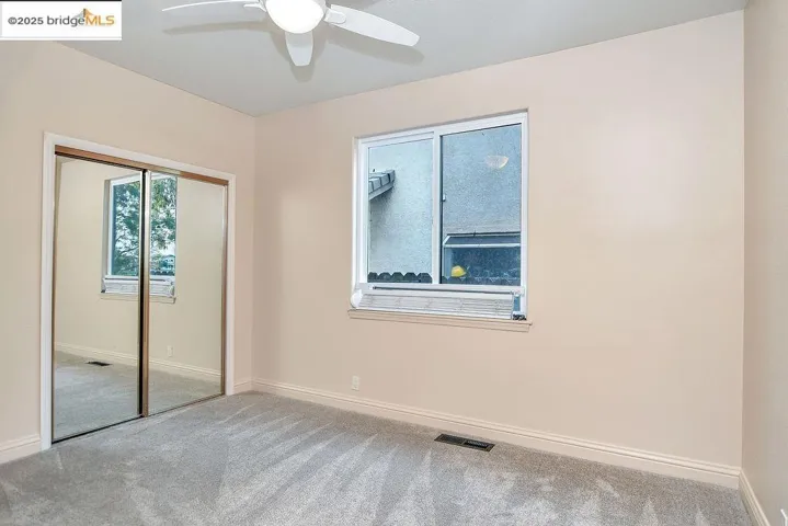 Unfurnished bedroom with carpet floors, a closet, and a ceiling fan