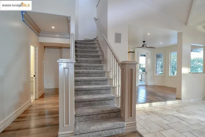 Stairs with wood finished floors, recessed lighting, and ceiling fan