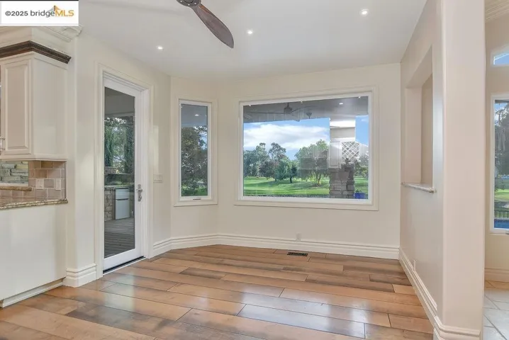 Unfurnished dining area with healthy amount of natural light, light wood-style floors, recessed lighting, and a ceiling fan