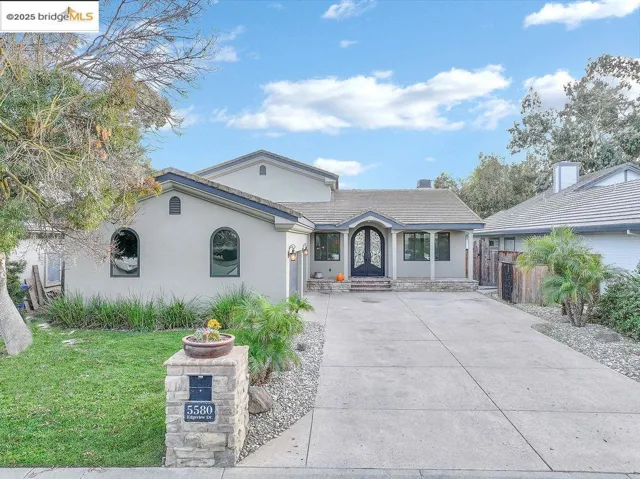 View of front facade featuring stucco siding and a front yard