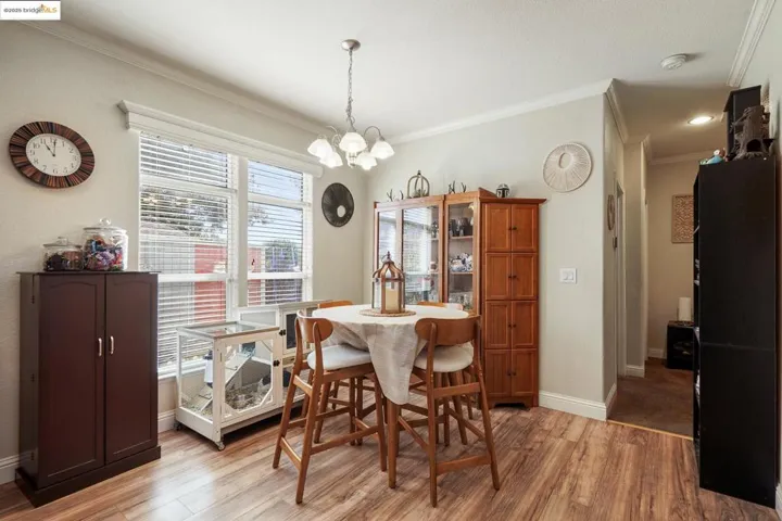Dining area featuring ornamental molding, light wood-style floors, and a chandelier