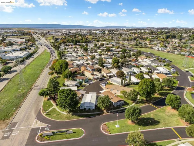 Aerial view of property's location with nearby suburban area and a mountainous background