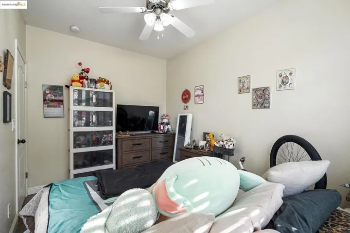Living area with ceiling fan and baseboards