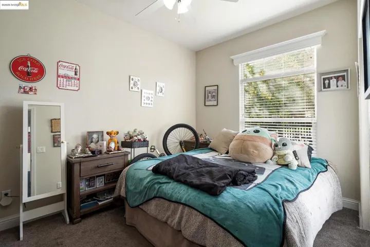 Carpeted bedroom with baseboards and a ceiling fan
