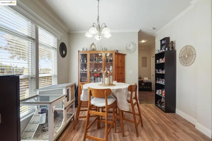 Dining space featuring ornamental molding, light wood-type flooring, and a chandelier