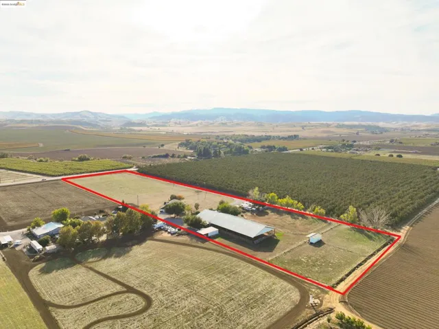 View of rural area with property parcel outlined, mountains, and farmland