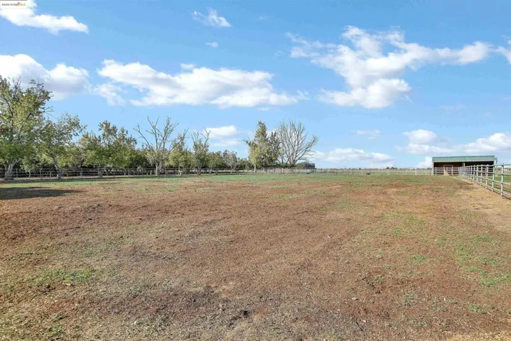 View of yard featuring a view of rural / pastoral area and an enclosed horse arena