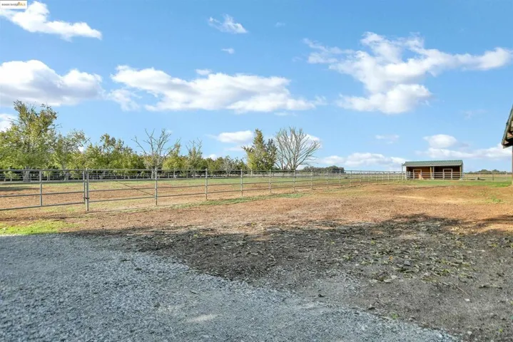 View of yard featuring an outbuilding, a view of rural / pastoral area, an enclosed horse arena, and an exterior structure