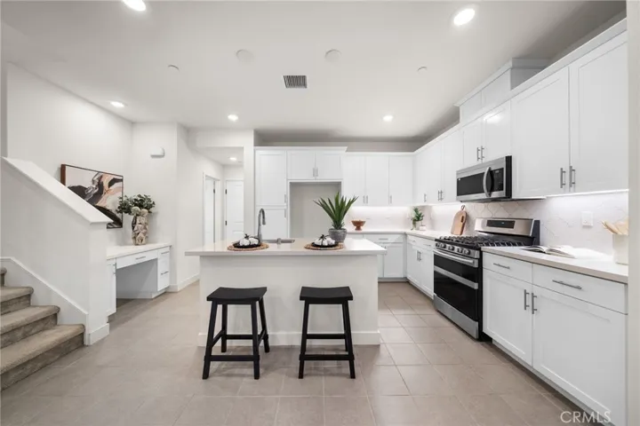 Staged Gourmet Kitchen with Built In Desk, Pantry, Quartz Counter Top, 1st Floor Recessed Lights.
