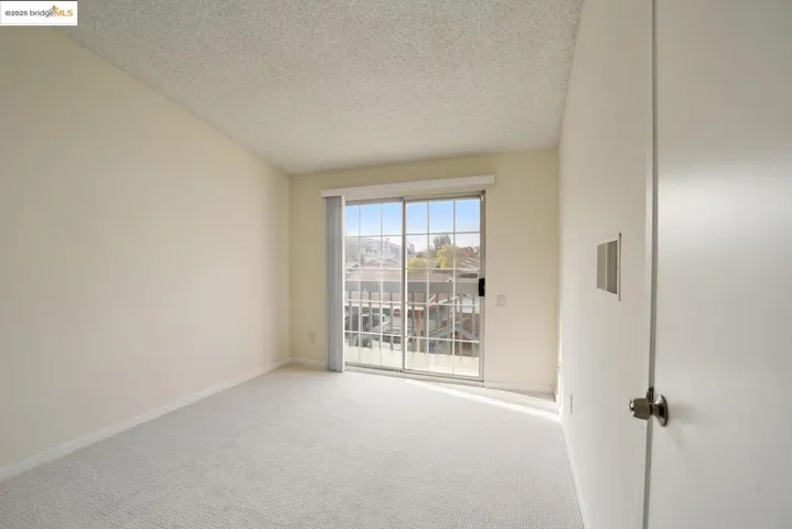 Empty room with carpet and a textured ceiling