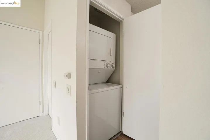Washroom with stacked washer / drying machine and carpet