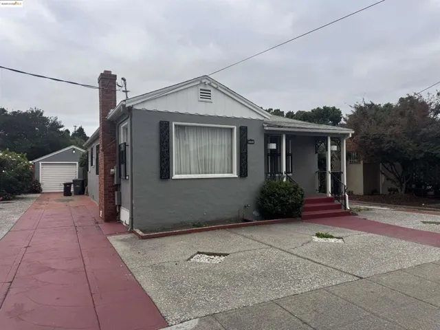 Bungalow-style house with a chimney, an outbuilding, stucco siding, board and batten siding, and covered porch