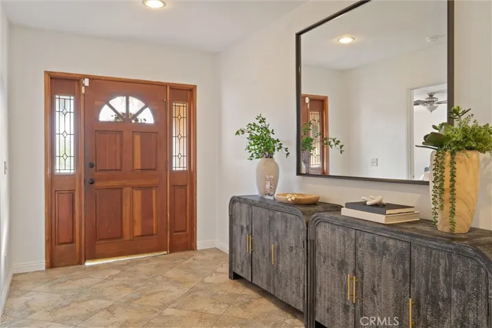 Spacious tiled entryway with coat closet