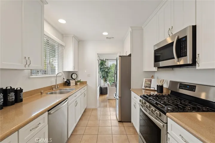 Kitchen with white shaker cabinets & stainless steel appliances