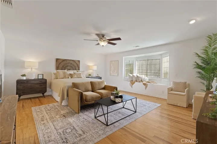 Spacious primary bedroom with room for multiple sitting areas, a desk or workout area.