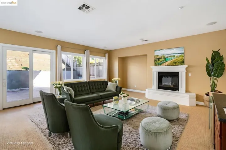 Carpeted living area featuring baseboards and a glass covered fireplace