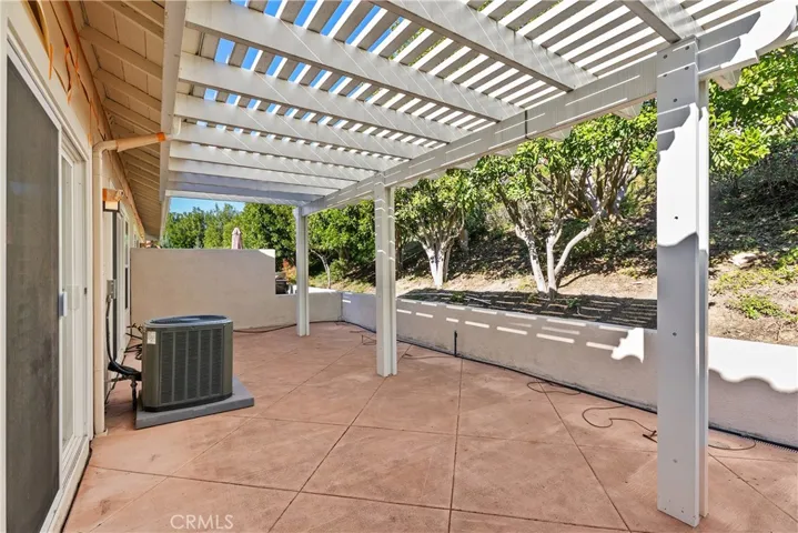 The large, private, covered patio features a backdrop of beautiful trees.
