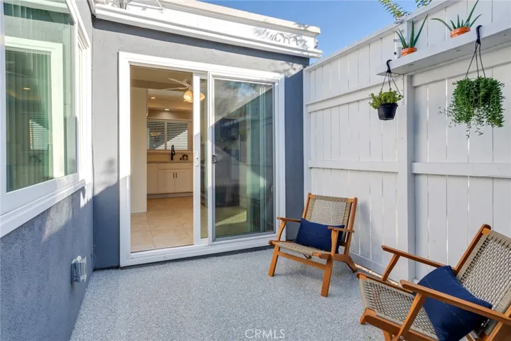 Charming private patio with new epoxy flooring, ideally situated between the kitchen/dining area and the garage—perfect for relaxing or casual outdoor enjoyment.