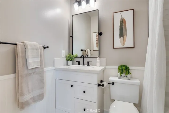 Updated full bathroom featuring a shower/tub combination, new mirror, new lighting, and modern fixtures for a clean, refreshed look.