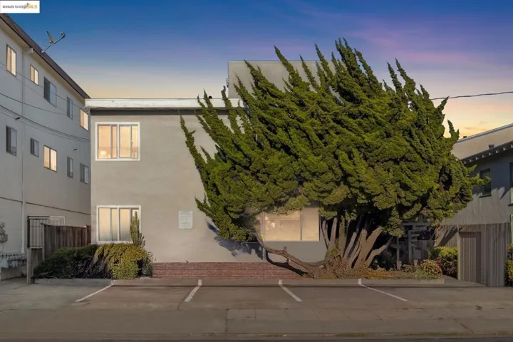 View of front of home with stucco siding and uncovered parking