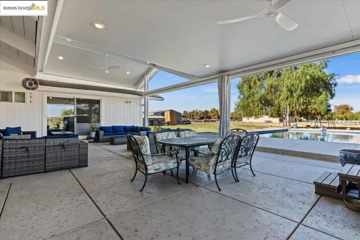 View of patio with a ceiling fan, outdoor lounge area, an outdoor pool, and outdoor dining space