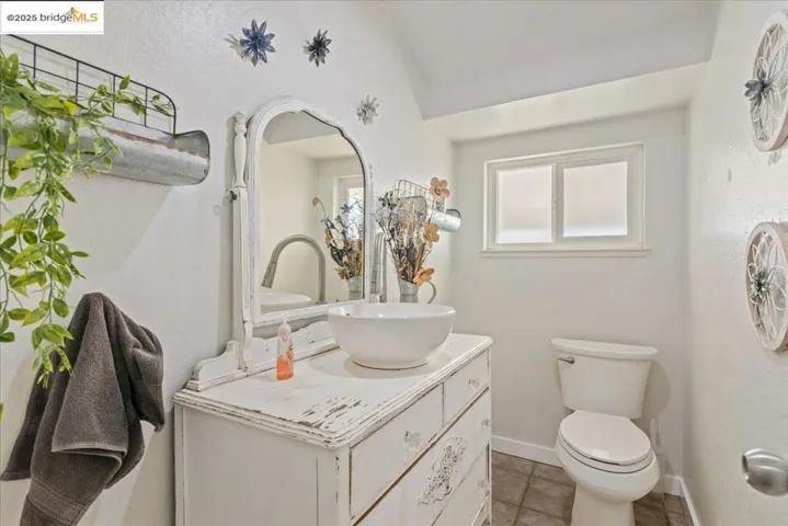 Half bath with vanity, light tile patterned floors, and a textured wall